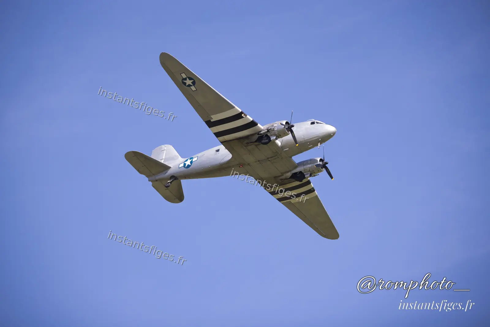 Avion de transport historique aux bandes de débarquement, vu de dessous en vol